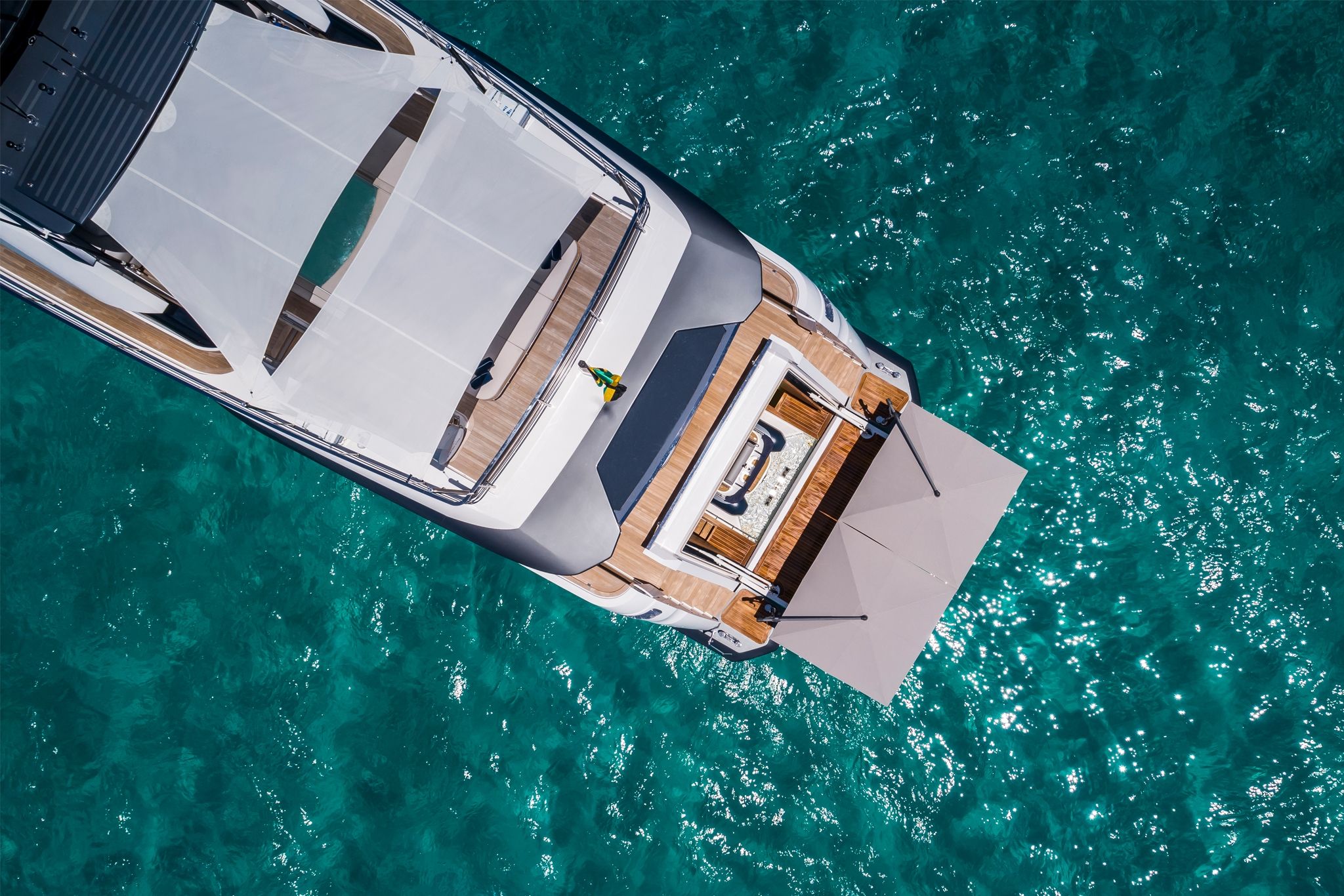 Overhead view of the luxurious yacht, Custom Line 120' floating on calm, serene waters under a bright sky.