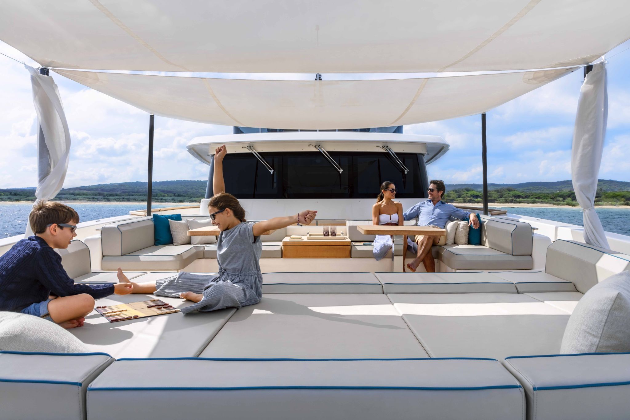 Family relaxing on the shaded aft deck of the Custom Line Navetta 42 during a day cruise.