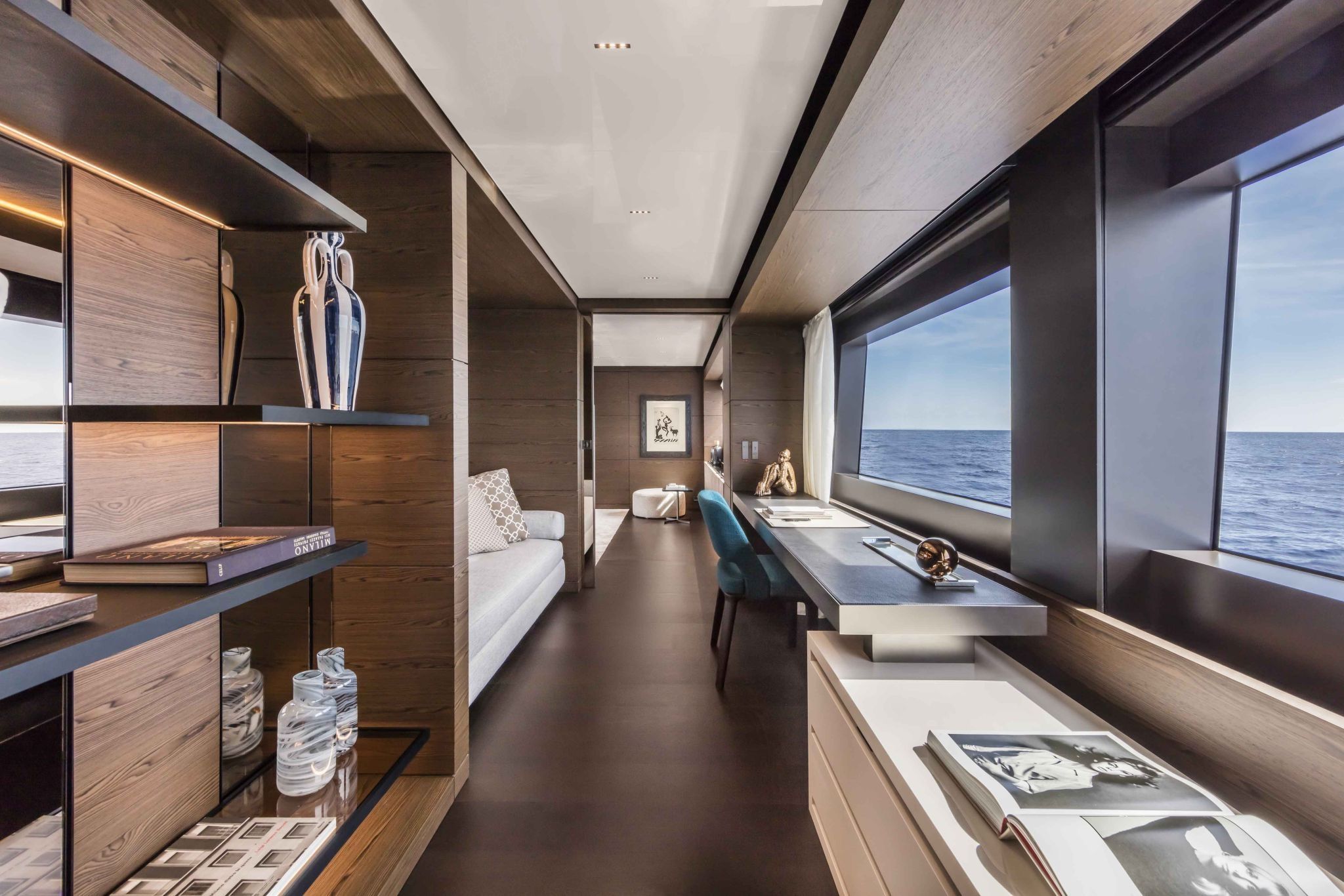 Custom Line Navetta 42 upper deck lounge with bronze, linen, and honed stone finishes.