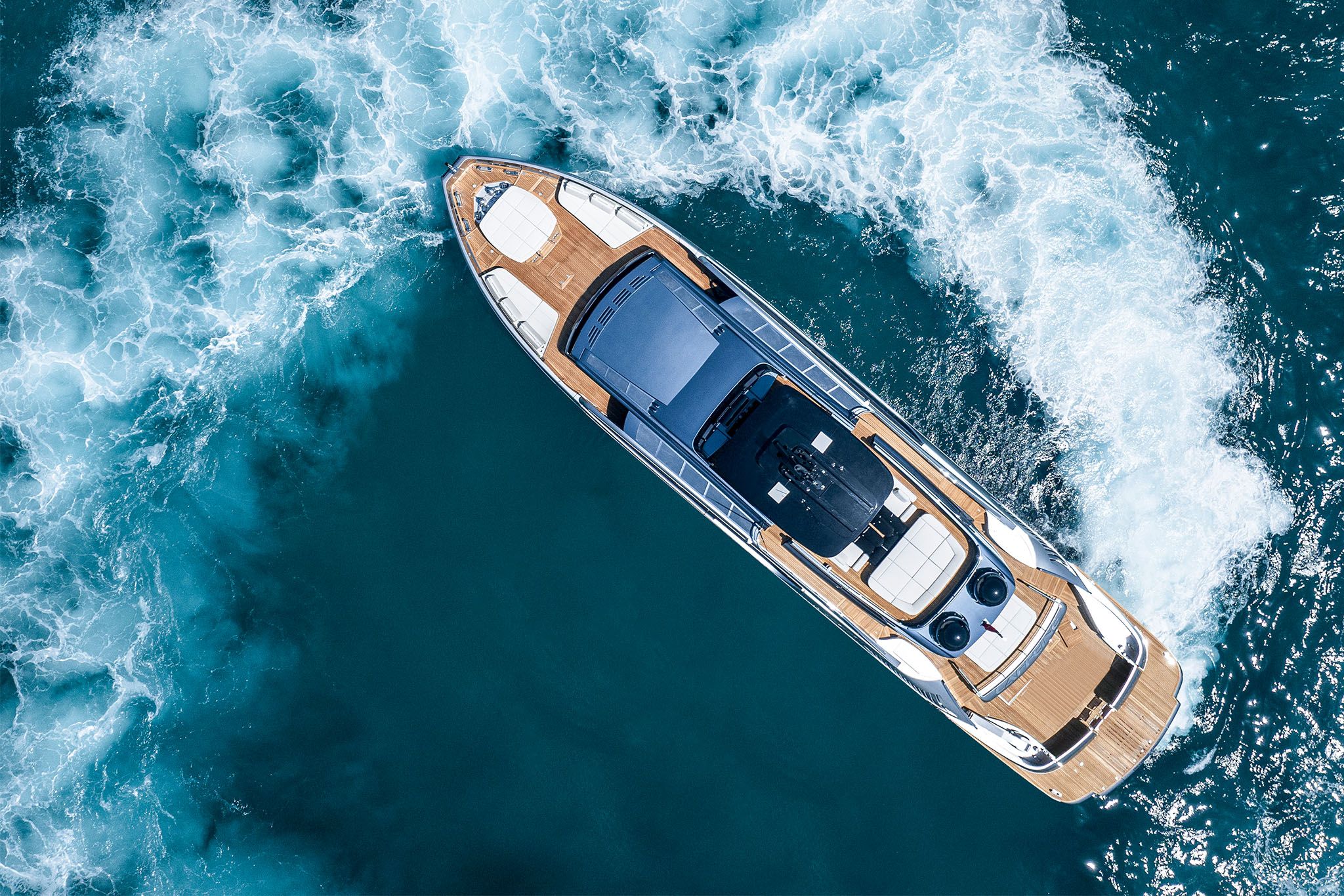 Overhead perspective of a sleek Pershing GTX116 yacht drifting through the ocean waves, showing off its agility.