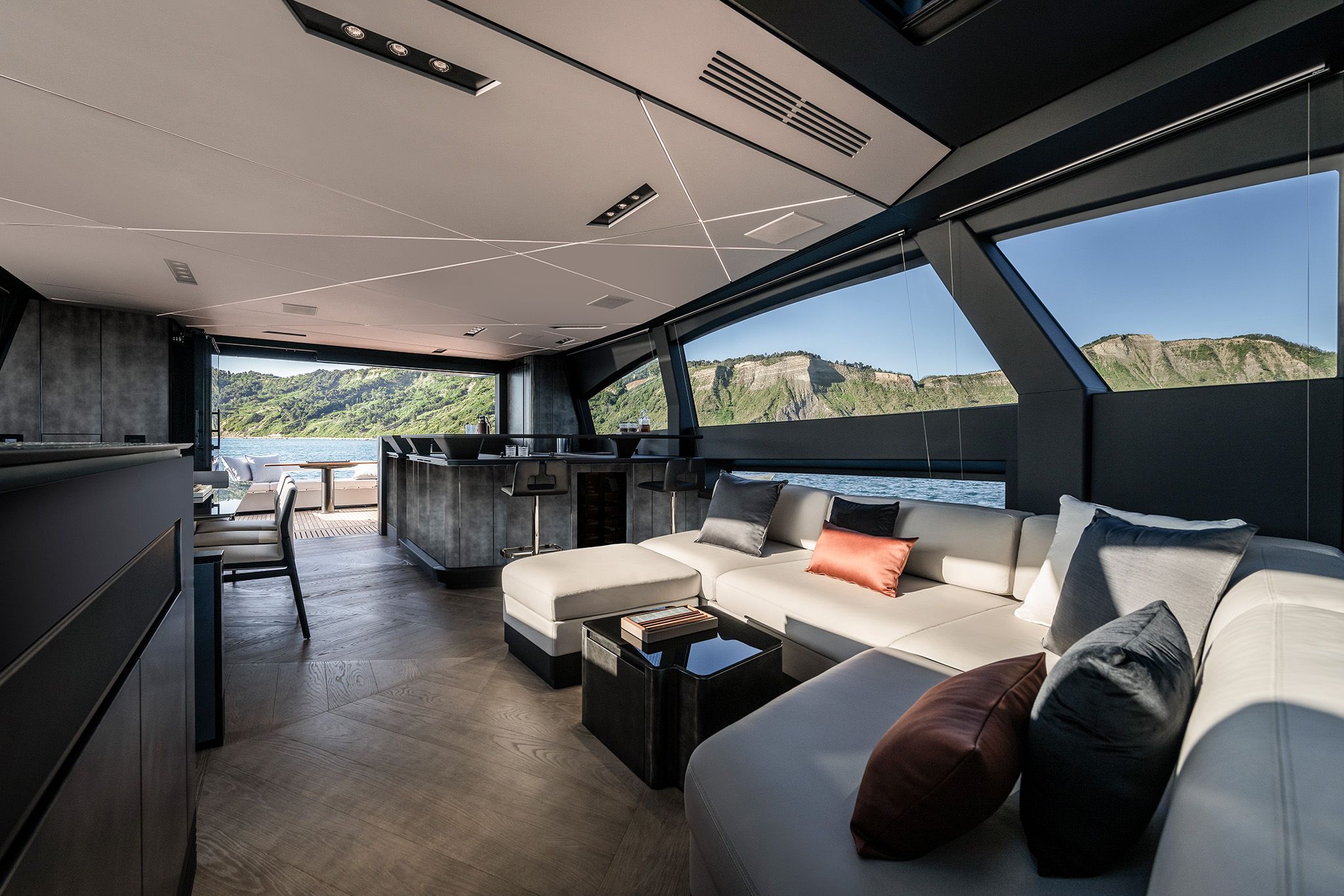 View of the modern interior of the Pershing GTX80 with blue sea and mountains in the background