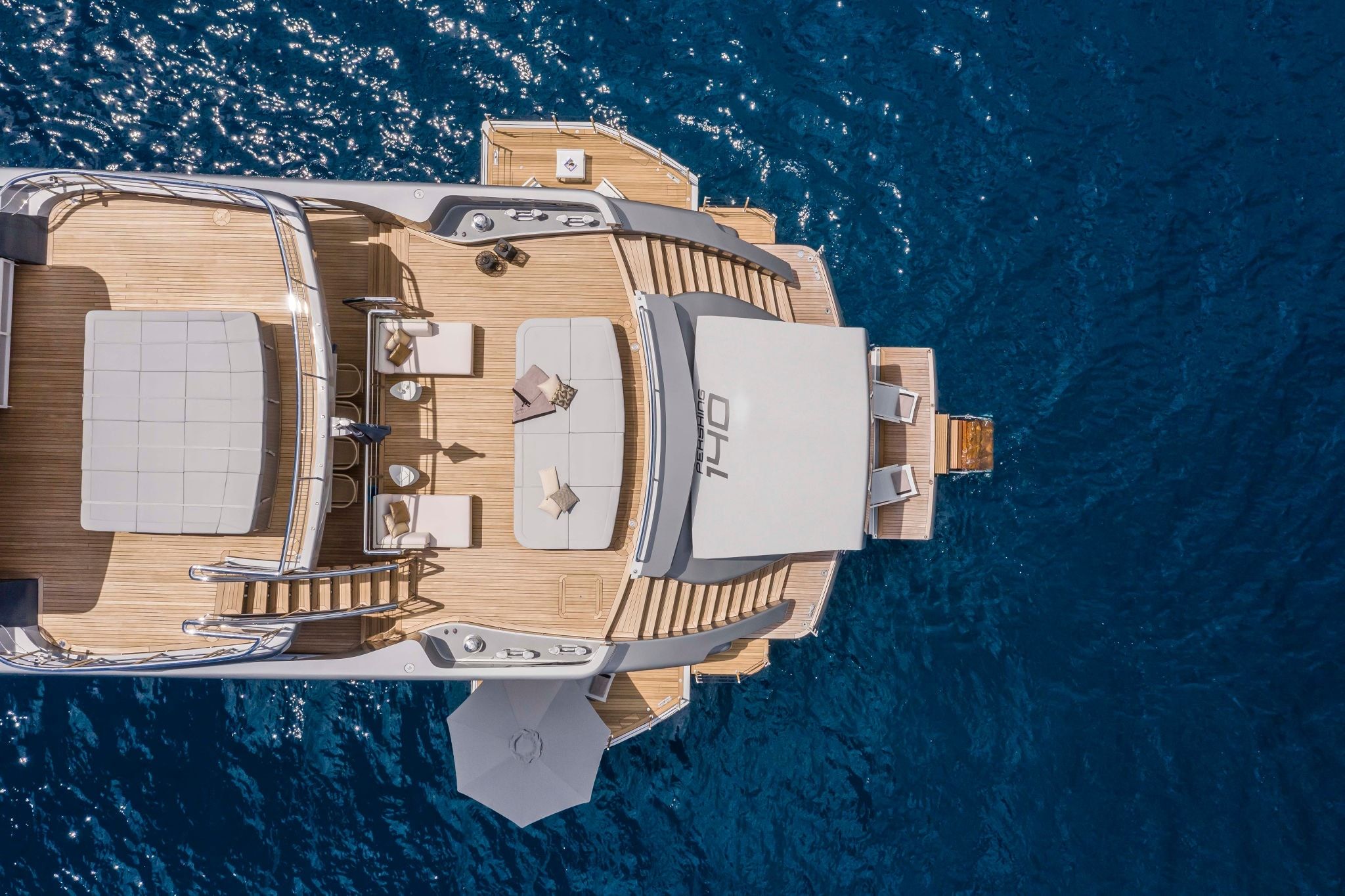 A view of a luxurious white and brown Pershing 140 sailing in the deep blue ocean.