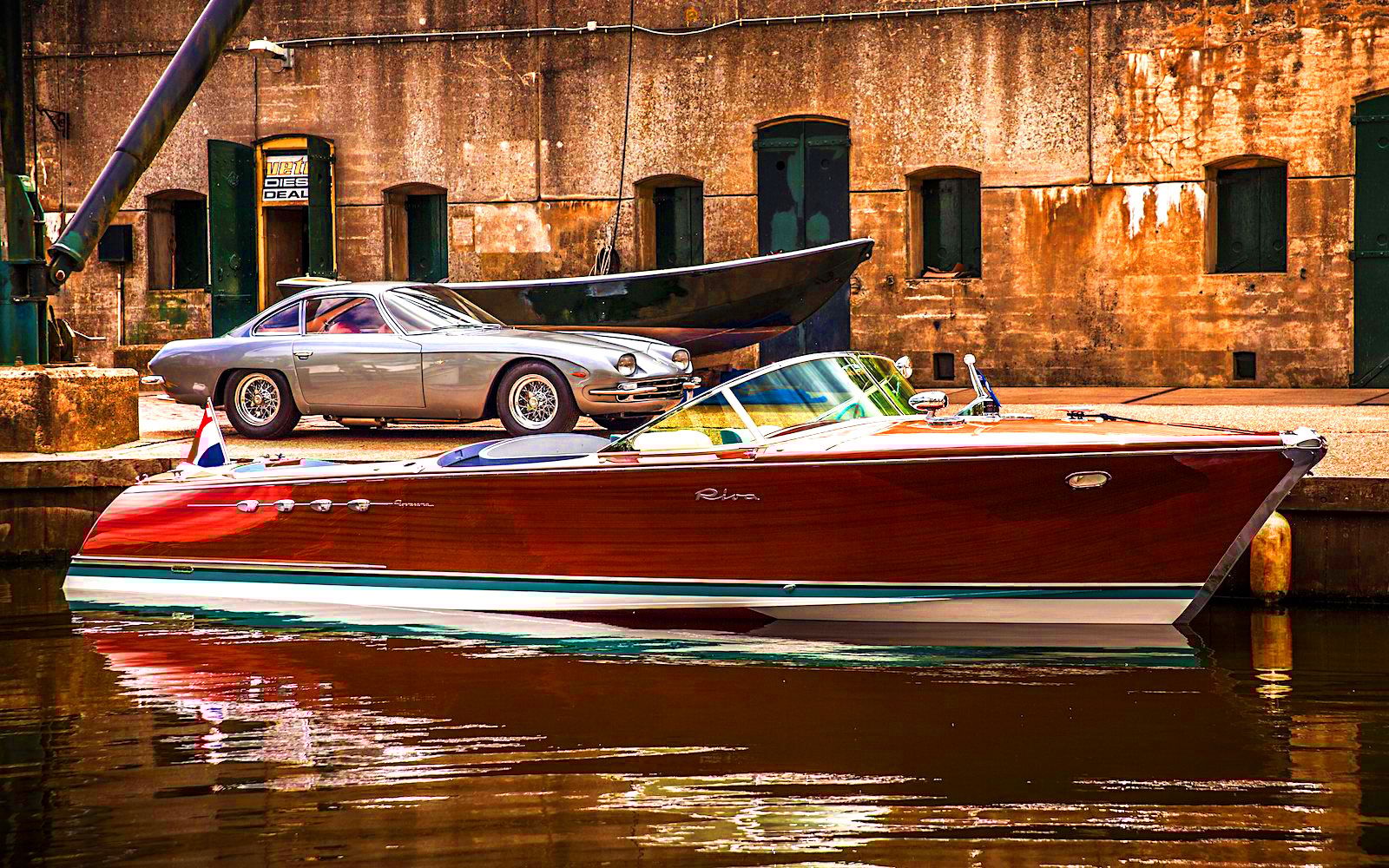A vintage Riva docked in front of a classic Lamborghini car