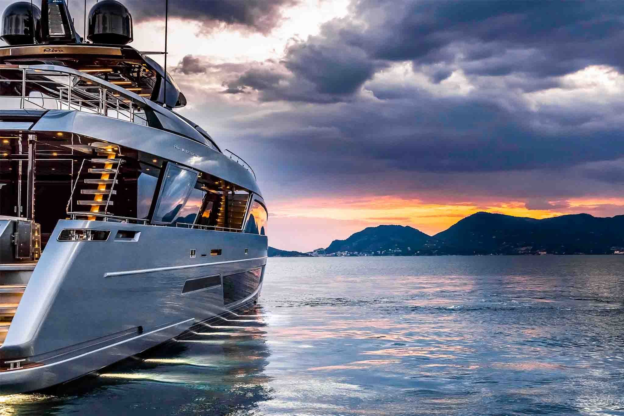 Riva 110 anchored at dusk with sunset view