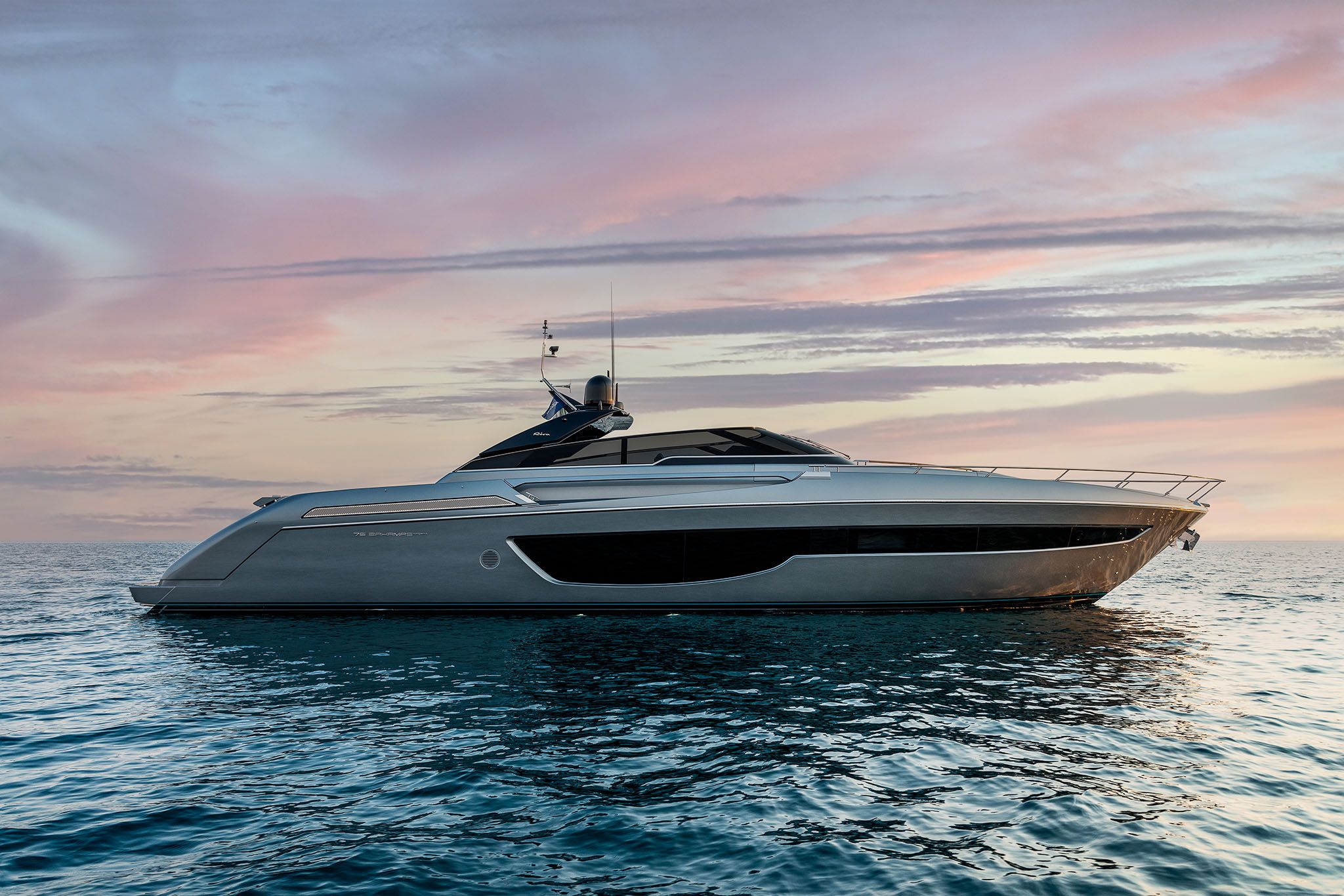 Riva Yacht: A white 76'Bahamas cruises beautifully during sunset.