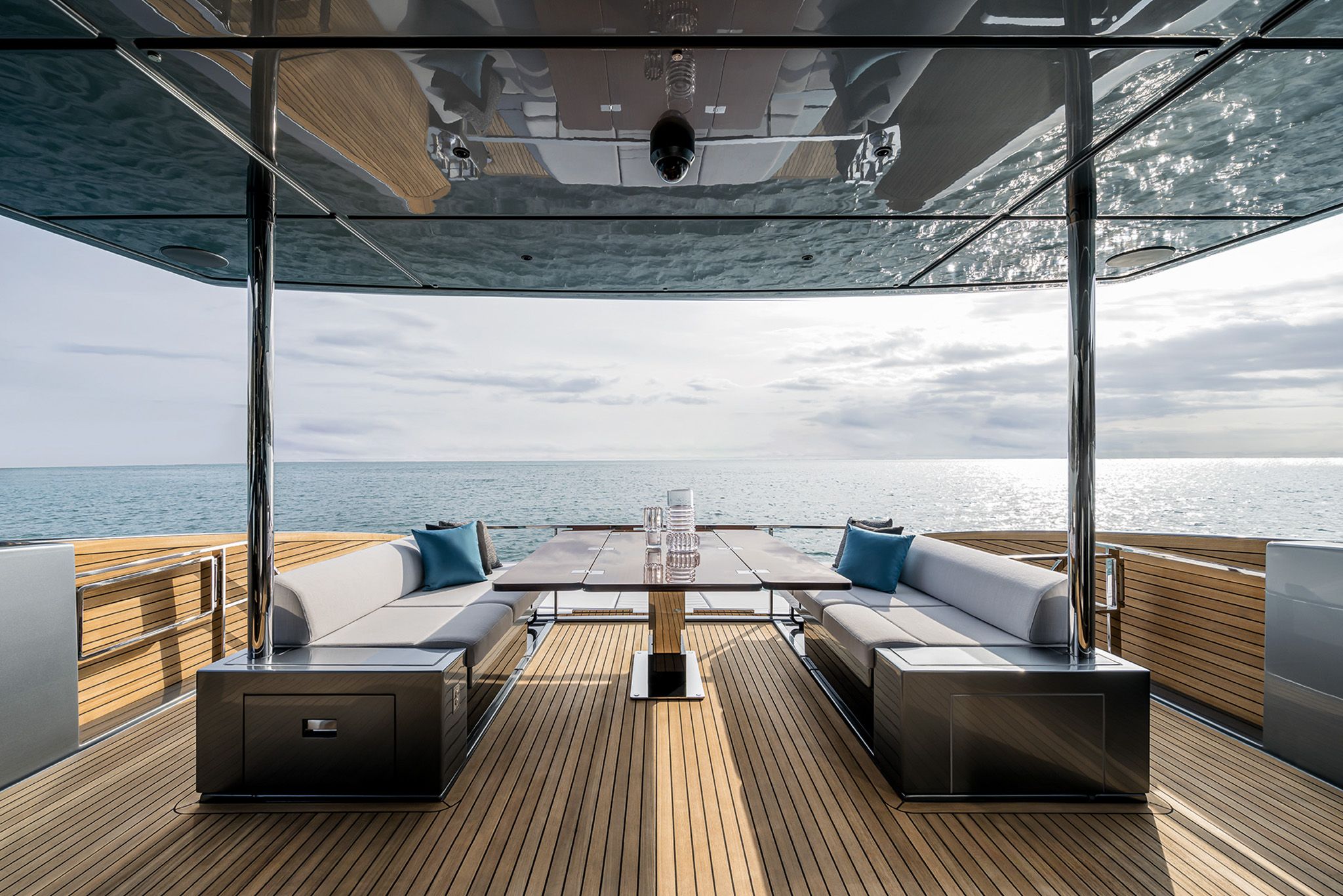 Riva Diva 82 main deck outdoor dining area overlooking the sunset and clam seas. 