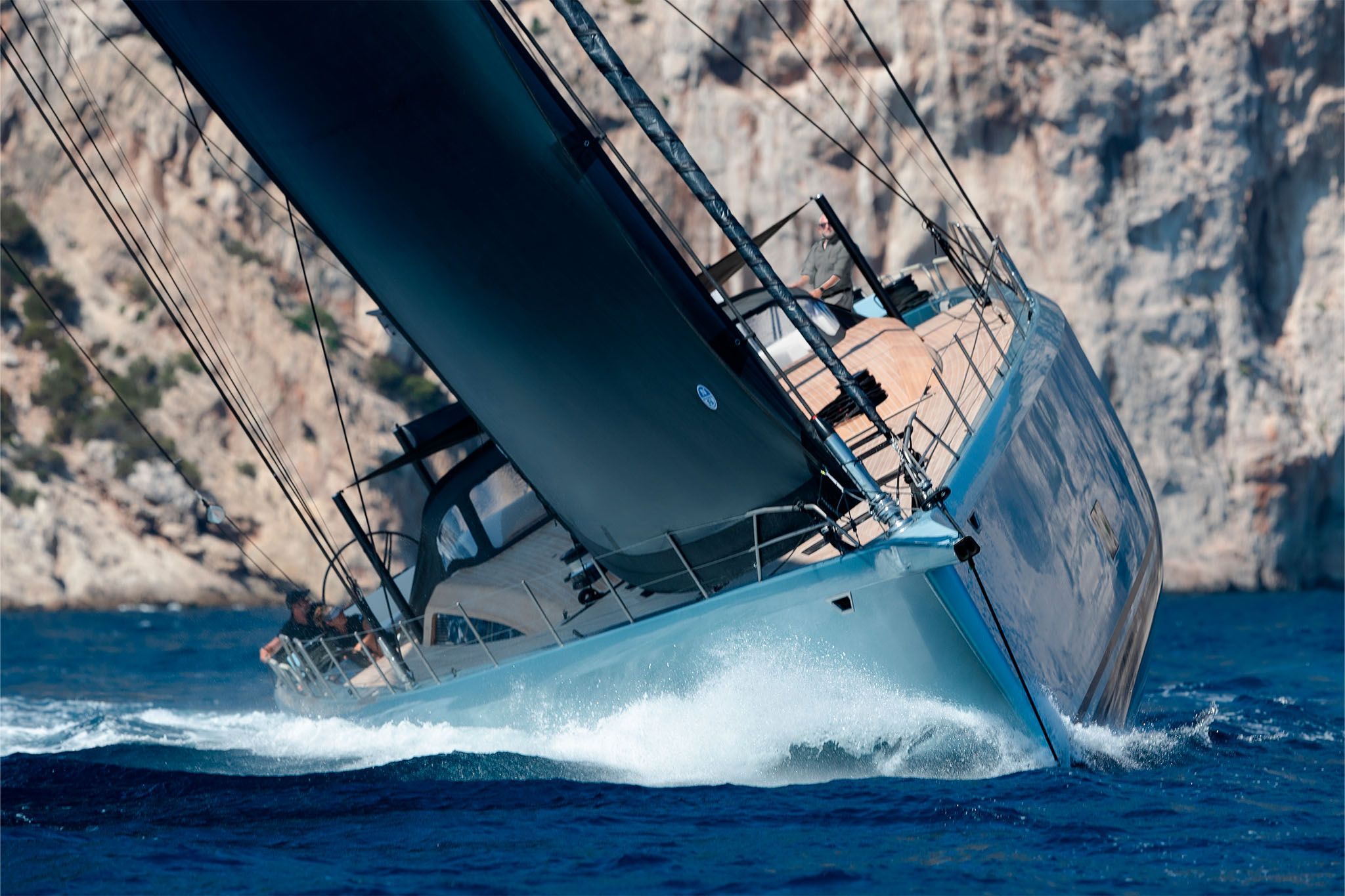 The Wallywind 110 yacht sailing dynamically through the waves with its sleek sail and modern design.