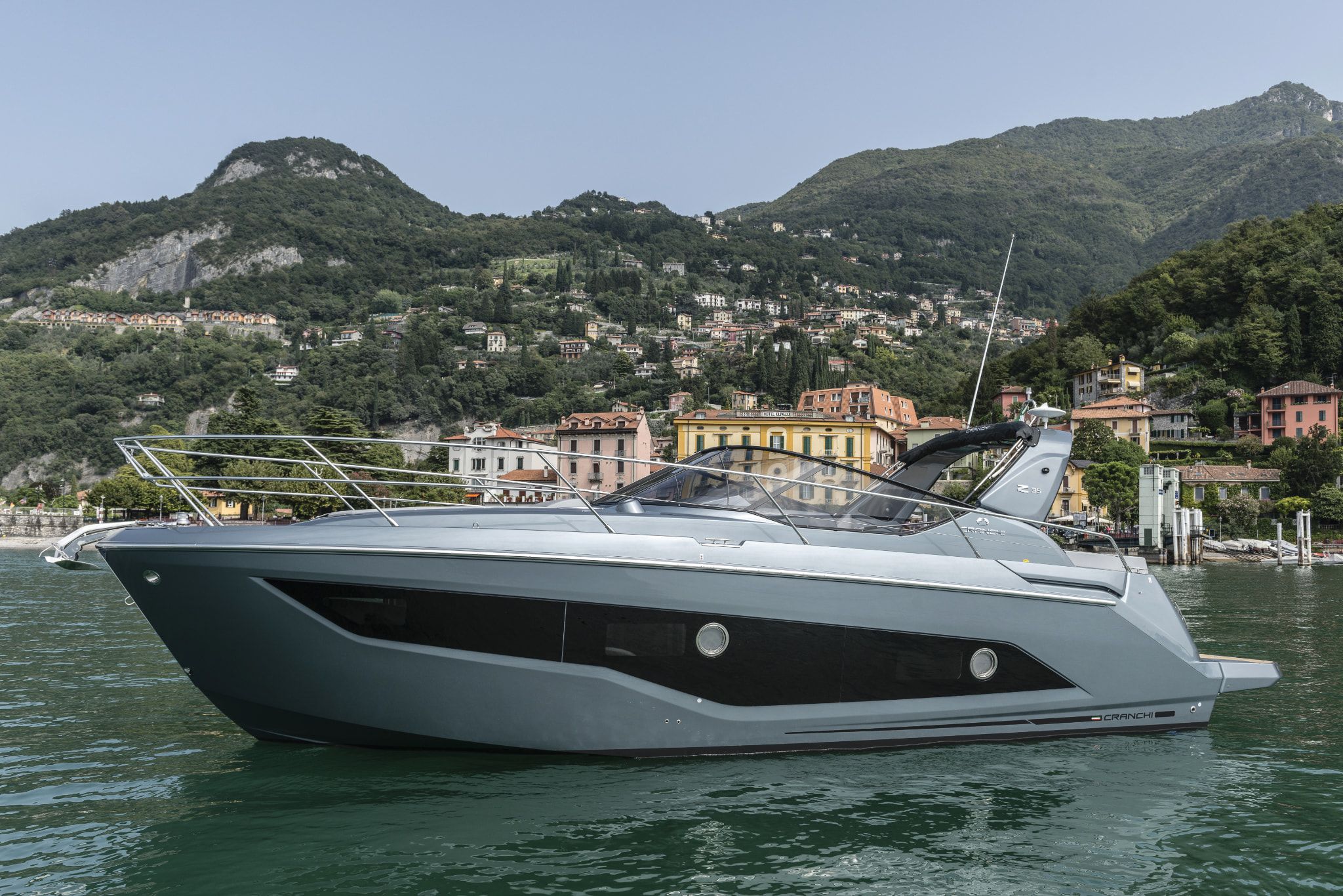 Cranchi Yacht: A white Z35 floating on the serene waters nearby a cityscape under a bright sky.