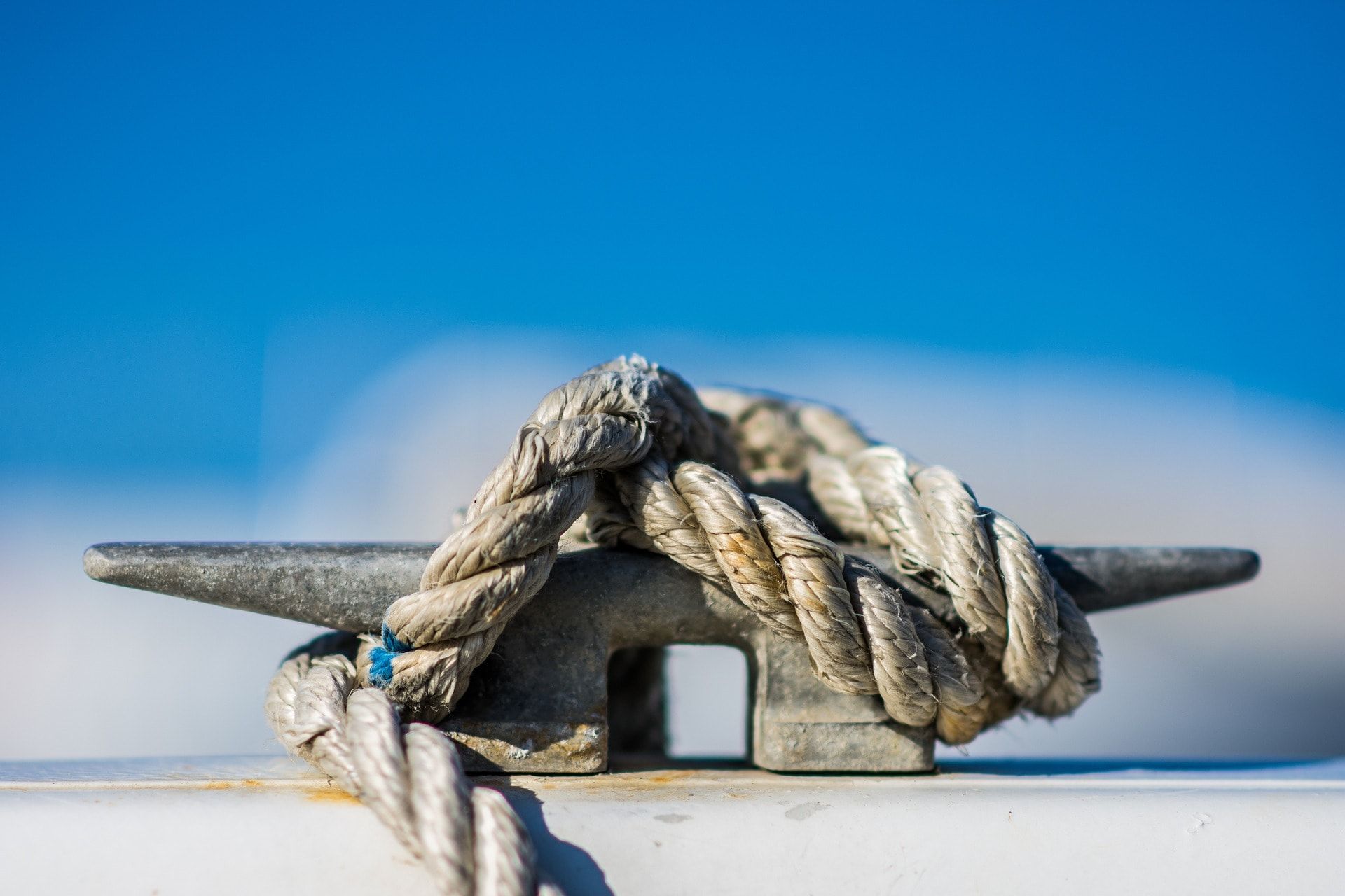 Boat Equipment: a rope tied to a metal hook on a boat deck.