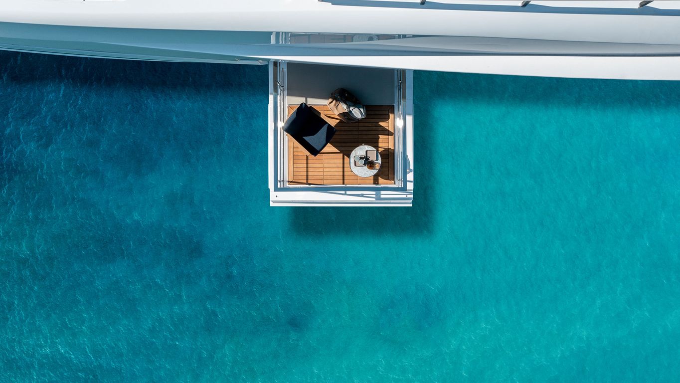 Cozy lounge on a Custom Line 140 main deck, yacht by Starship Yachts, overlooking clear blue waters.