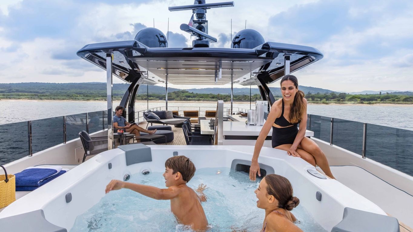 Spacious deck on Custom Line Navetta 42 yacht with a jacuzzi and comfortable seating for a family-friendly experience.