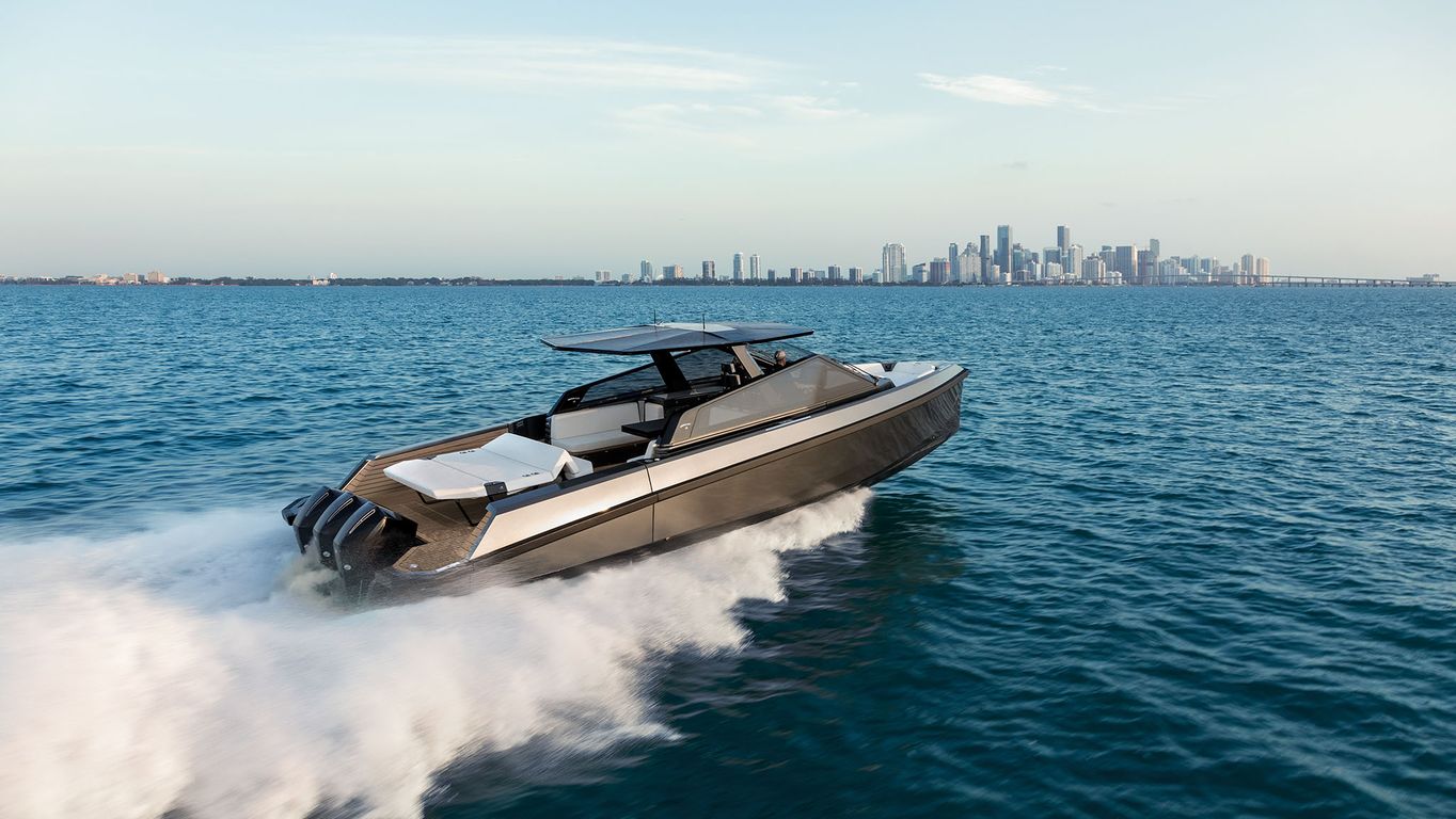 Side view of Wally 43x cutting through the water with city skyline in the background.