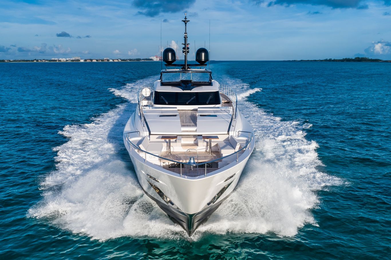 Custom Line yacht moving fast, front view showing dynamic ocean wake, presented by Starship Yachts.