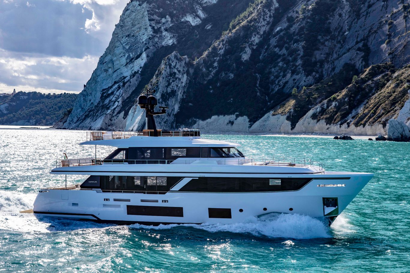 A sleek, white yacht Custom Line Navetta 30 gliding smoothly through the blue ocean waves.