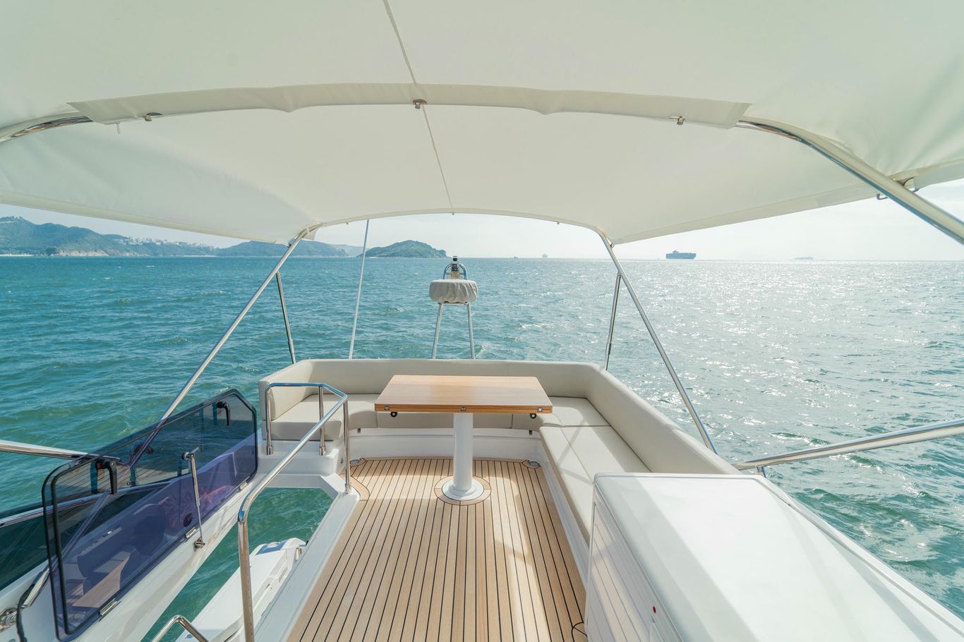 Flybridge on Ferretti Yachts 500 with teak decking, white seating, and retractable canopy for open-air leisure