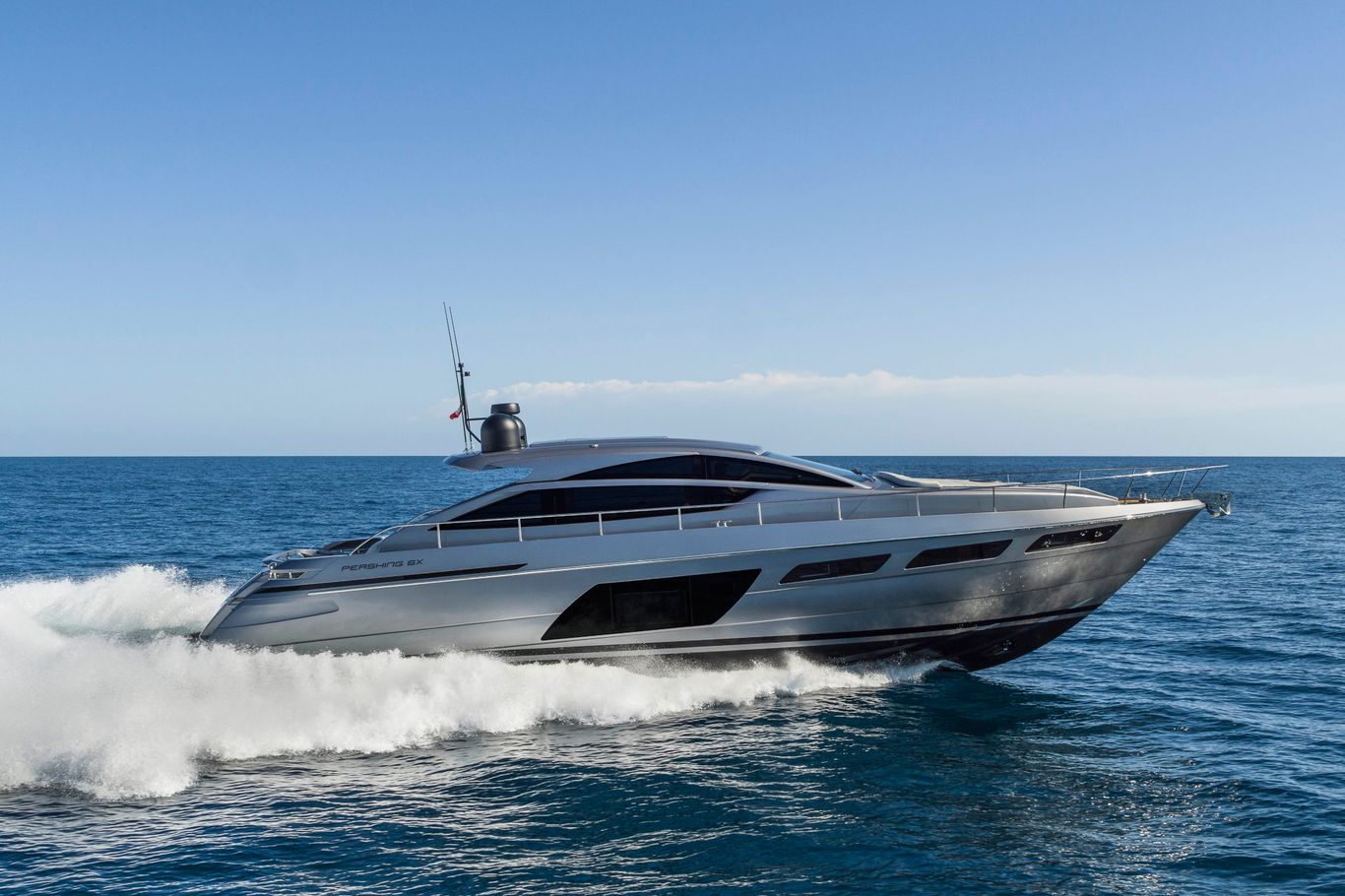 Pershing Yacht: An opulent Pershing 6X cruising through the sea, creating waves.