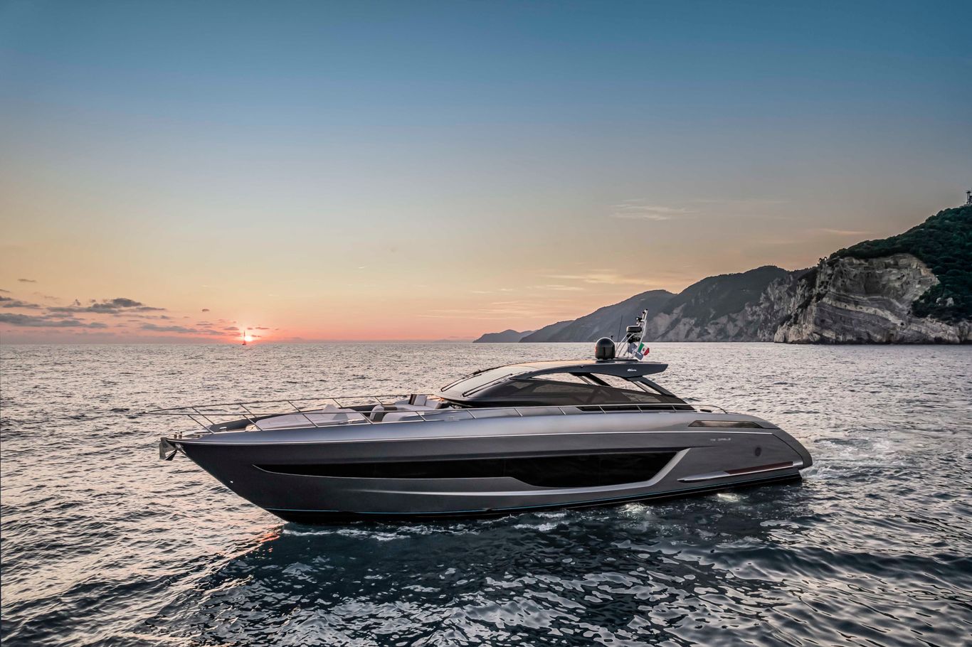 A lavish 68'Diable by Riva gliding through the ocean by the mountains.