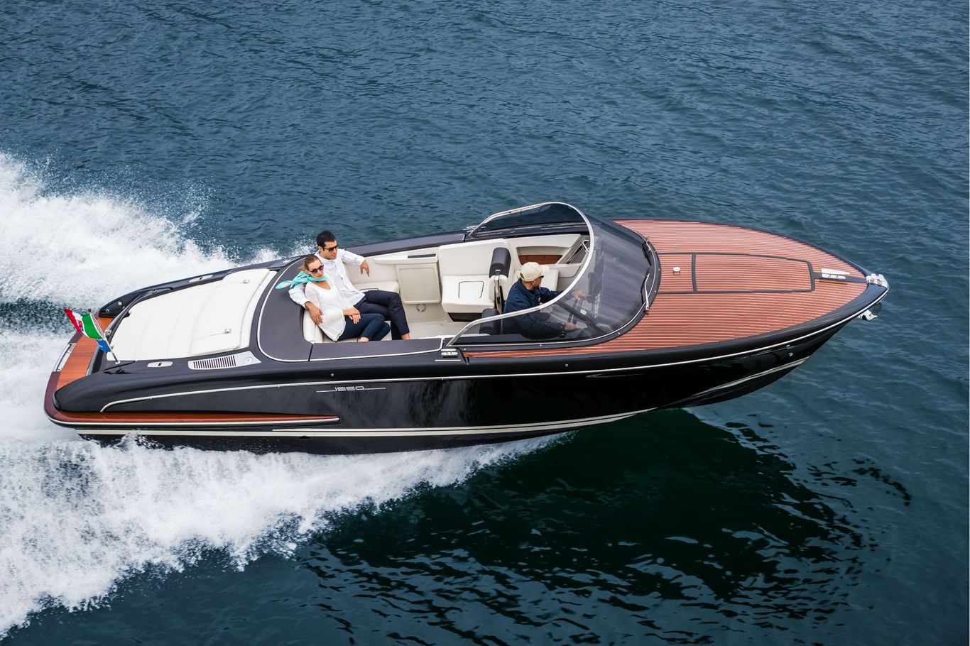 A man and woman speeds through the ocean waves stylishly on a luxurious Iseo by Riva.
