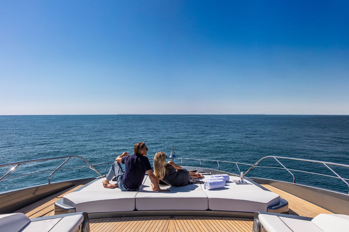 Relaxing on the deck of a Riva 110' Dolcevita yacht while enjoying the view of the vast blue ocean.