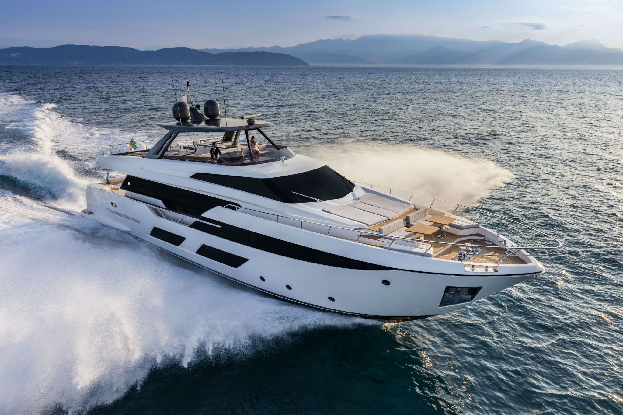 An elegant, white Ferretti yacht 920 speeding across the deep blue sea.