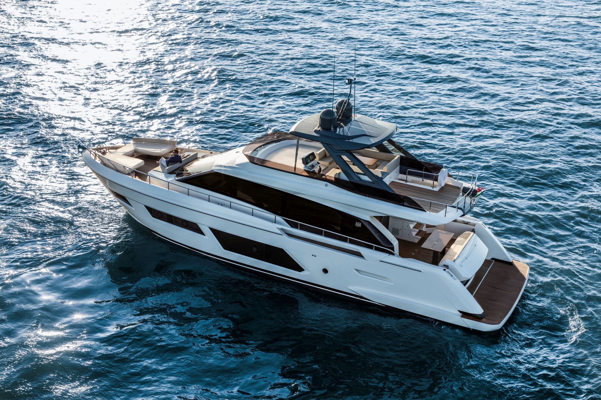 A white and brown coloured Ferretti Yacht 670 floating graciously on the open sea.