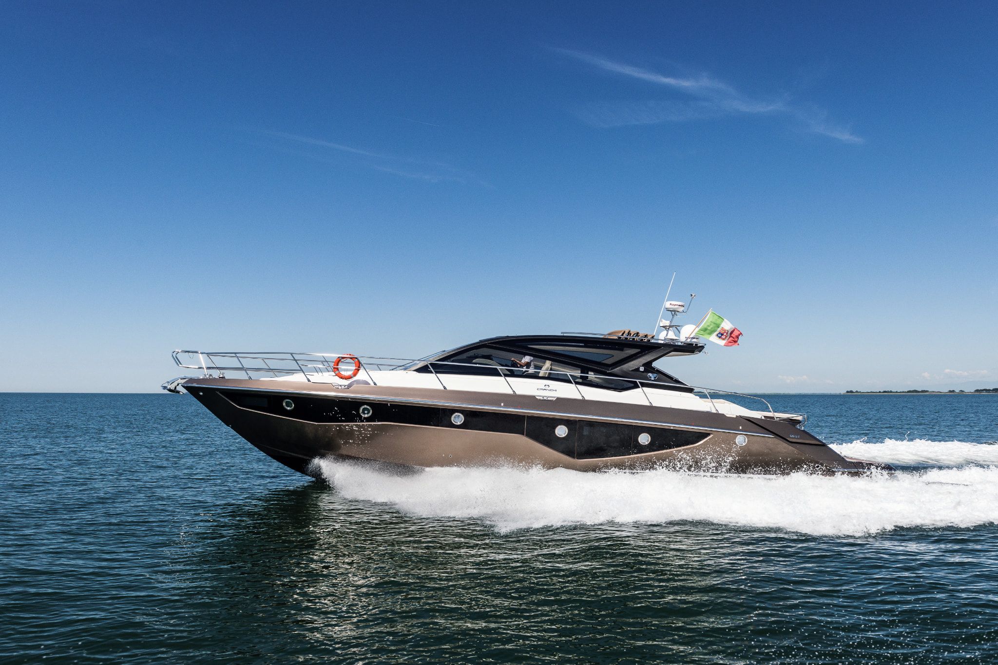 60ST by Cranchi Yachts, a white and gold yacht cruising stylishly through the blue waters.