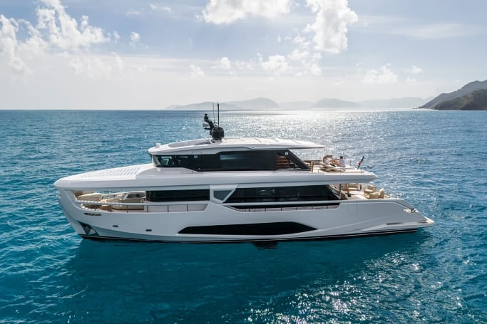 Hong Kong Yacht: A luxurious white Ferretti Yachts Infynito 90 moored on the surface of a blue ocean under a cloudy sky.