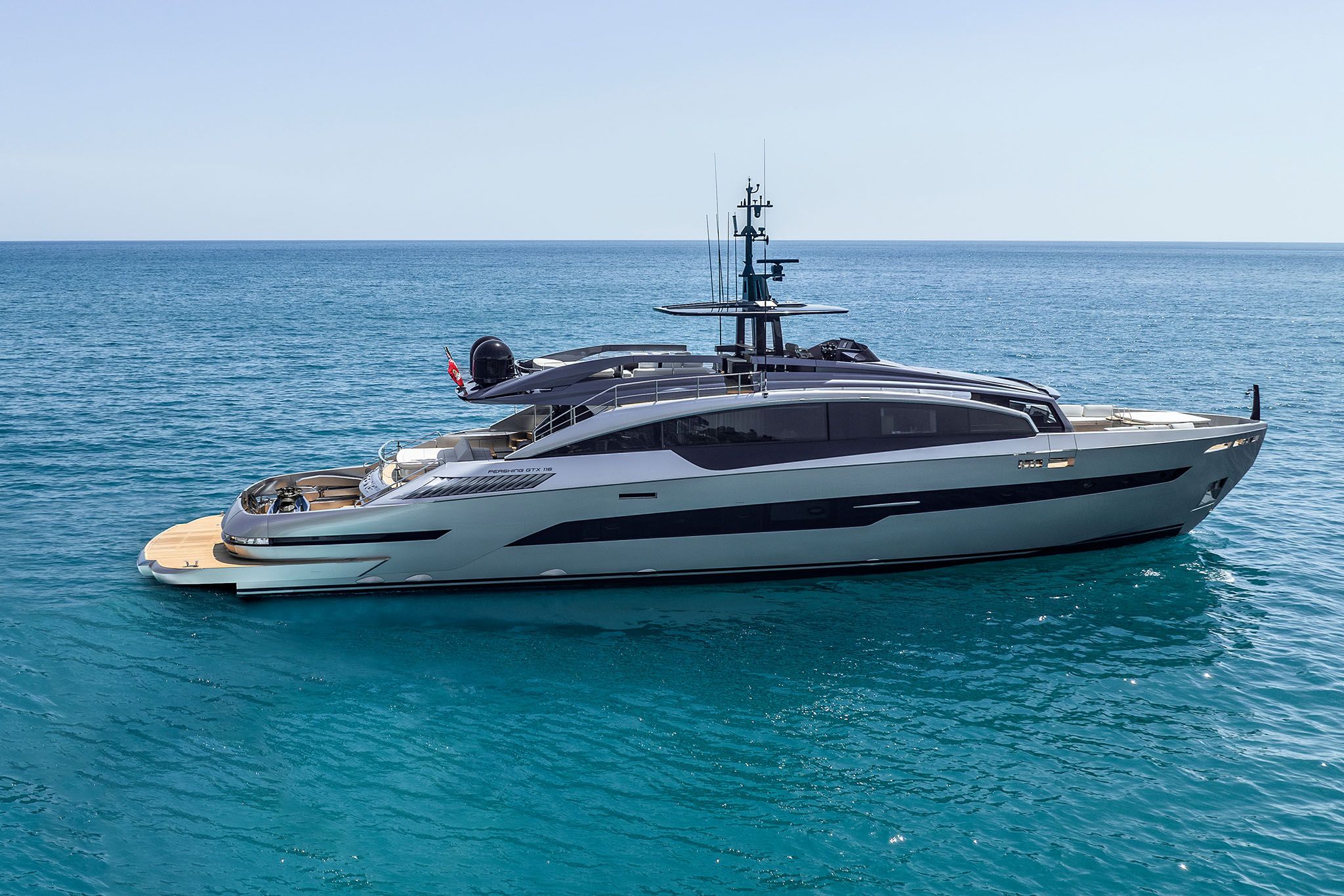 A deluxe white Pershing GTX116 showcased on the open water under a bright sky.