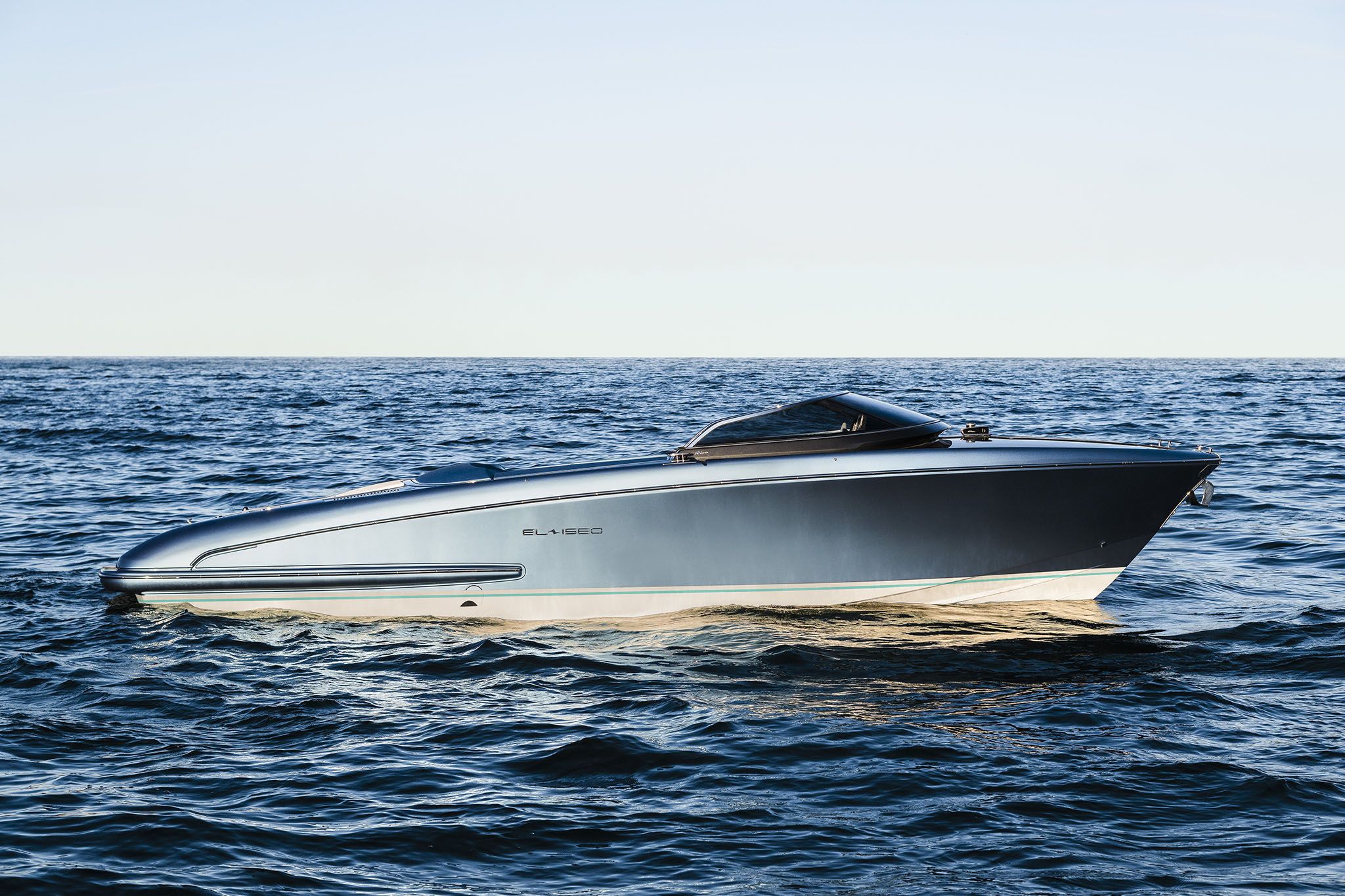 A posh El-Iseo by Riva floats graciously on the deep blue ocean waves on a bright day.