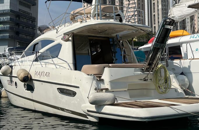 Cranchi yacht, Atlantique 43 docked in serene waters next to other yachts.