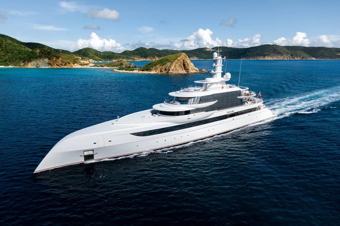 A majestic, white superyacht Excellence displayed for sale while sailing gracefully through the open ocean waves.