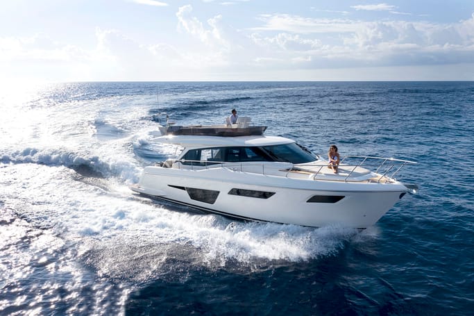 Ferretti Yachts 500: A man and woman cruising stylishly on the blue sea.