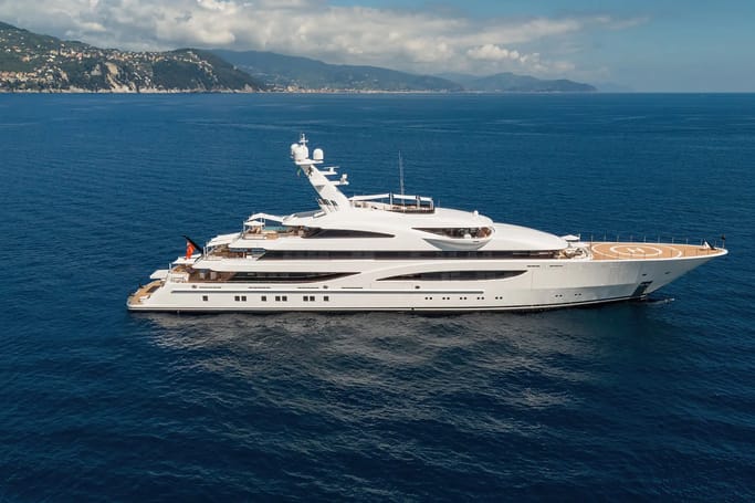 From Lurssen-Werft, Gigia, a white superyacht with helipad cruising on the sea on a bright day.