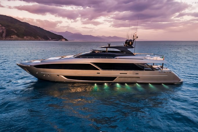 A luxurious white yacht, Riva 110 cruising confidently across the grand sea waves under a beautiful sky.