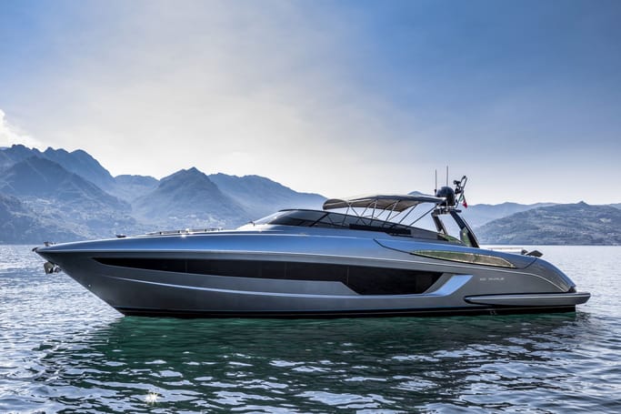 A sleek 56'Rivale showcased on the open water by the mountains for sale.