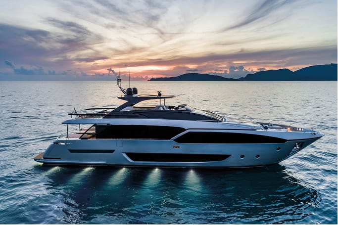 Riva Yacht: A massive white and black 90'Argo cruising beautifully during a sunset on the ocean.