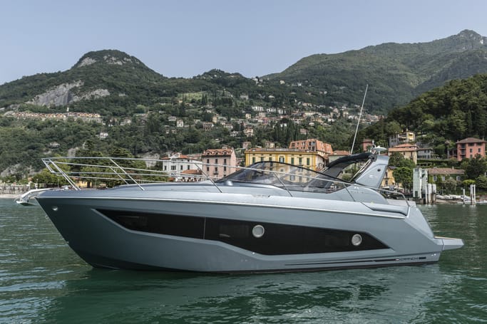 Cranchi Yacht: A white Z35 floating on the serene waters nearby a cityscape under a bright sky.