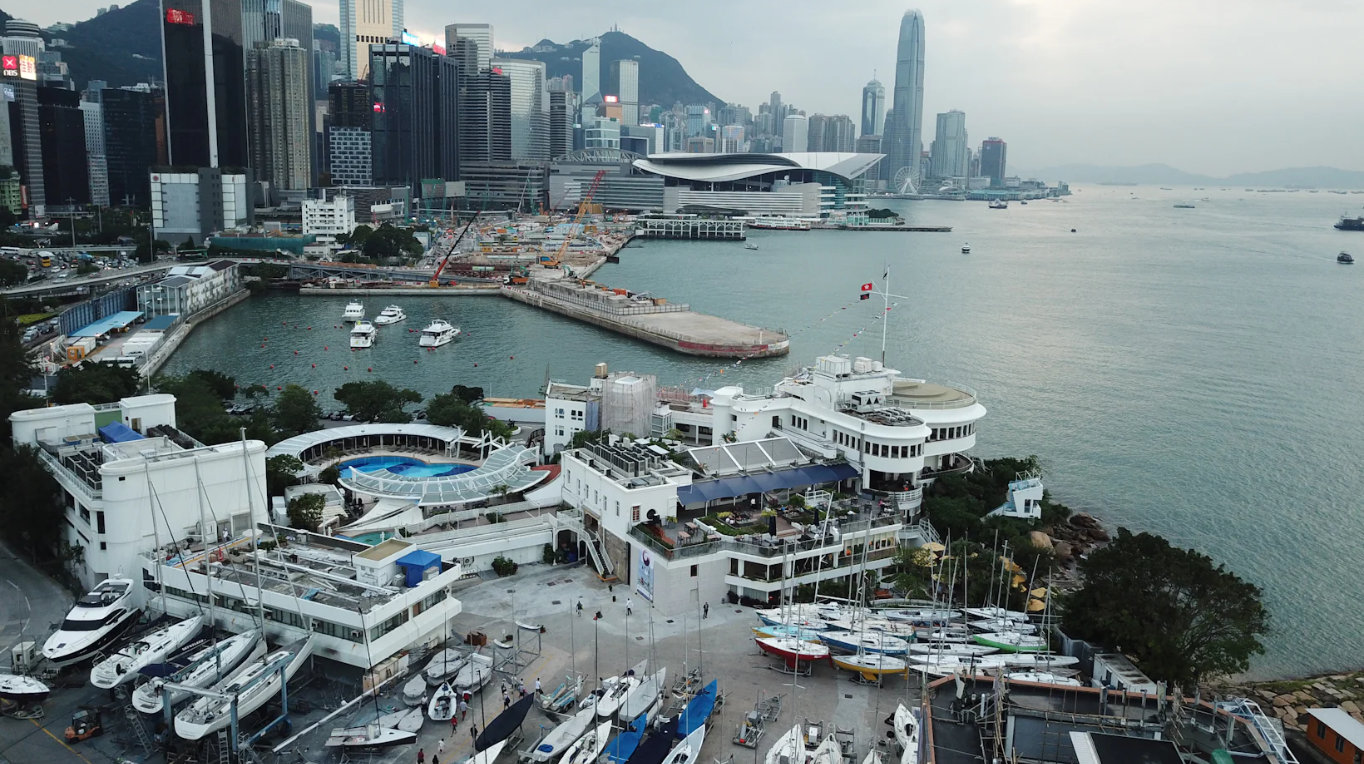 Arial view of Royal Hong Kong Yacht Club with Central cityscape , Victoria Harbour and mountains in the background.