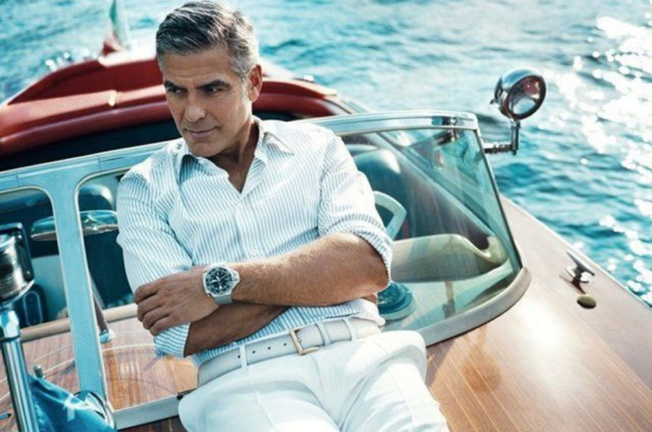 George Clooney sitting looking stylish  on his classic Riva